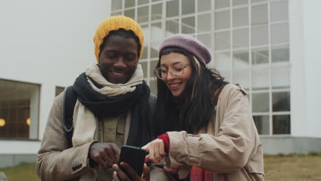 Cheerful-Diverse-Couple-Using-Smartphone-and-Discussing-Route-in-City